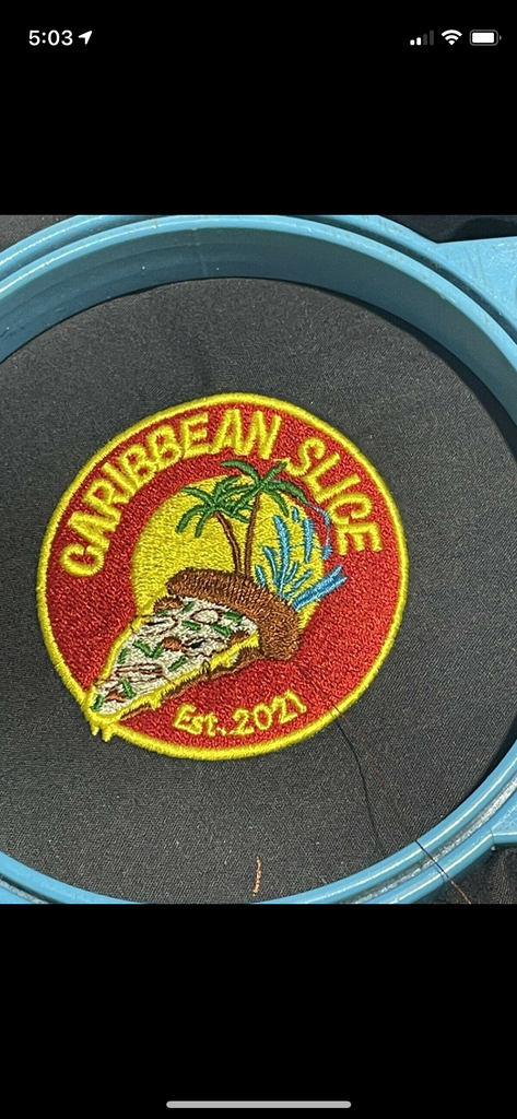 Embroidered pizza slice with palm trees and water splash in a circular patch with text Caribbean Slice Est. 2021